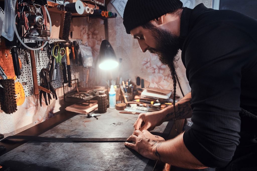 busy-workshop-talented-master-is-making-his-masterpeace-from-leather